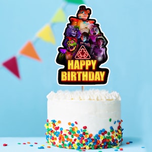 May include: A white frosted cake with colorful sprinkles at the base. A cake topper features a group of animated characters and the words "HAPPY BIRTHDAY" in yellow and black.