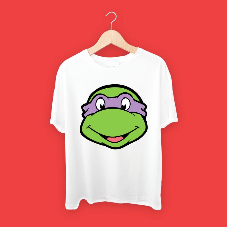 May include: White t-shirt with a green and purple Teenage Mutant Ninja Turtles character face graphic.