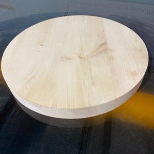 May include: A circular, unfinished wooden tabletop. The light-coloured wood grain is visible across the surface. The tabletop is approximately 3.8 cm thick and is ready for staining or painting. Ideal for DIY projects or as a replacement tabletop.