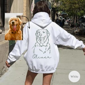 May include: White hoodie featuring a line drawing of a Golden Retriever and the name "Oliver". The hoodie has a hood and long sleeves. A photo of a Golden Retriever is in the upper left corner.