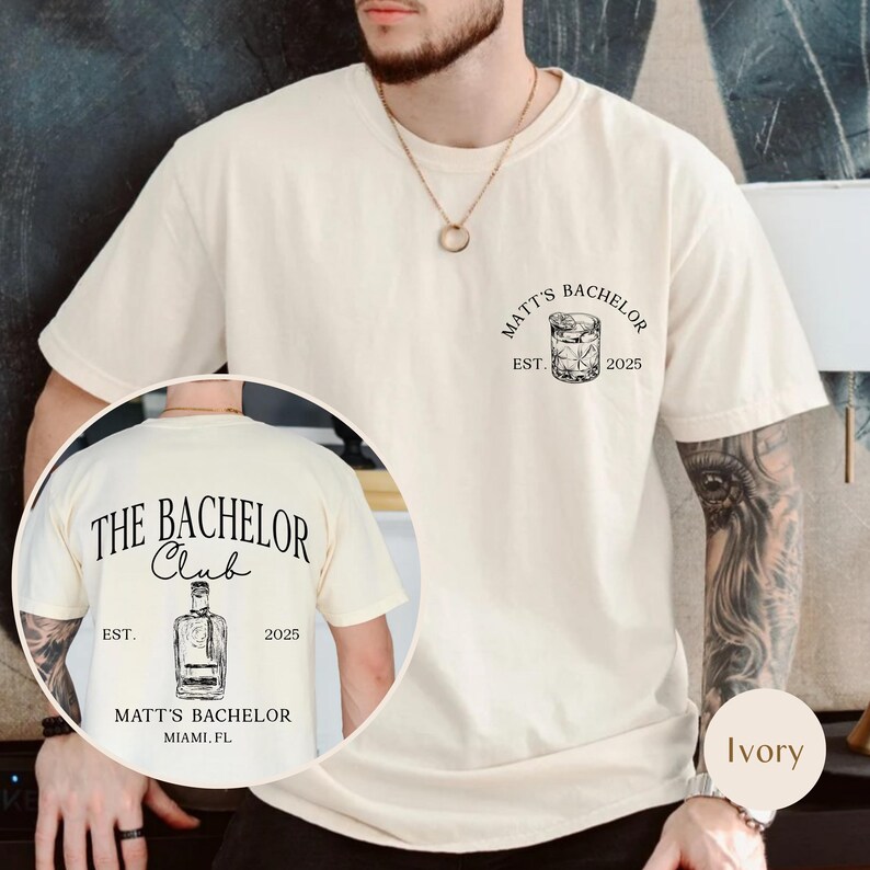 May include: Ivory-colored t-shirt with the text "MATT'S BACHELOR" and a graphic of a cocktail glass. The back of the shirt features the text "THE BACHELOR CLUB" with a bottle graphic, "EST. 2025" and "MATT'S BACHELOR MIAMI, FL."