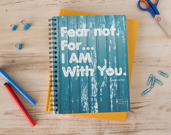 May include: A blue and yellow spiral bound notebook with the text "Fear not. For... I AM With You. Isaiah 41:10" on the front cover.
