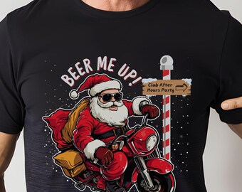 May include: Black t-shirt featuring Santa Claus riding a red motorcycle. Santa wears sunglasses and a Santa hat, with a bag of gifts. Text reads "BEER ME UP!" and "Club After Hours Party" on a sign.