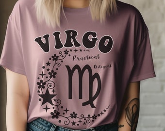 May include: A mauve t-shirt with a black graphic of the Virgo zodiac sign surrounded by stars and flowers. The text "Virgo...Practical...Diligent" is printed on the shirt.