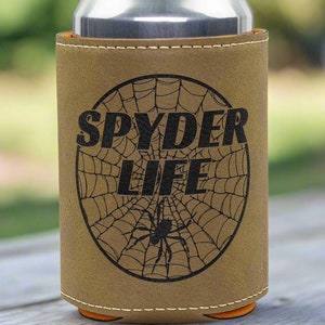 May include: A brown leather can cooler with a black spider web design and the text "SPYDER LIFE".