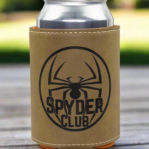 May include: A brown leather can cooler with a black spider and the text "SPYDER CLUB" in a circle.