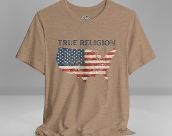 May include: A brown t-shirt with a distressed American flag design and the text "TRUE RELIGION" printed on the front.