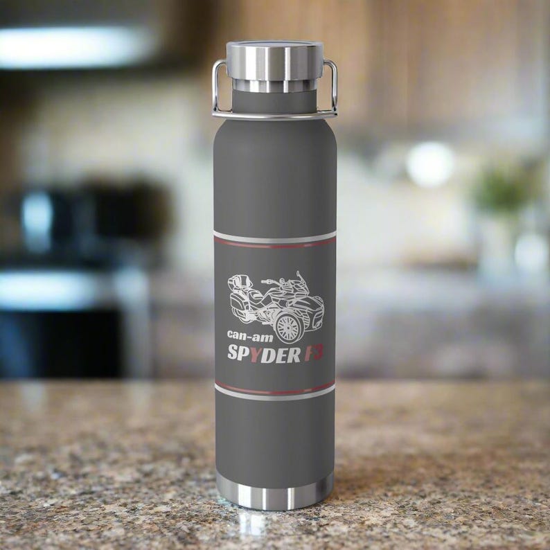 Pu&ograve; includere: Una borraccia isolante grigia con coperchio e manico argentati. La bottiglia presenta una grafica bianca di una moto Can-Am Spyder F3 e la scritta "can-am SPYDER F3". La bottiglia &egrave; progettata per mantenere le bevande fredde.