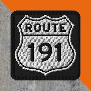 May include: Embroidered patch featuring a Route 191 sign in white and black. The patch has a shield shape with the words "ROUTE" above the number "191". The border is black, and the background is a textured gray.