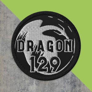 May include: Black and white embroidered patch featuring a dragon design and the text "Dragon 129".