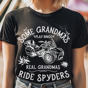 May include: Black t-shirt with white text that reads "Some Grandmas Play Bingo Real Grandmas Ride Spyders" and a white silhouette of a motorcycle.
