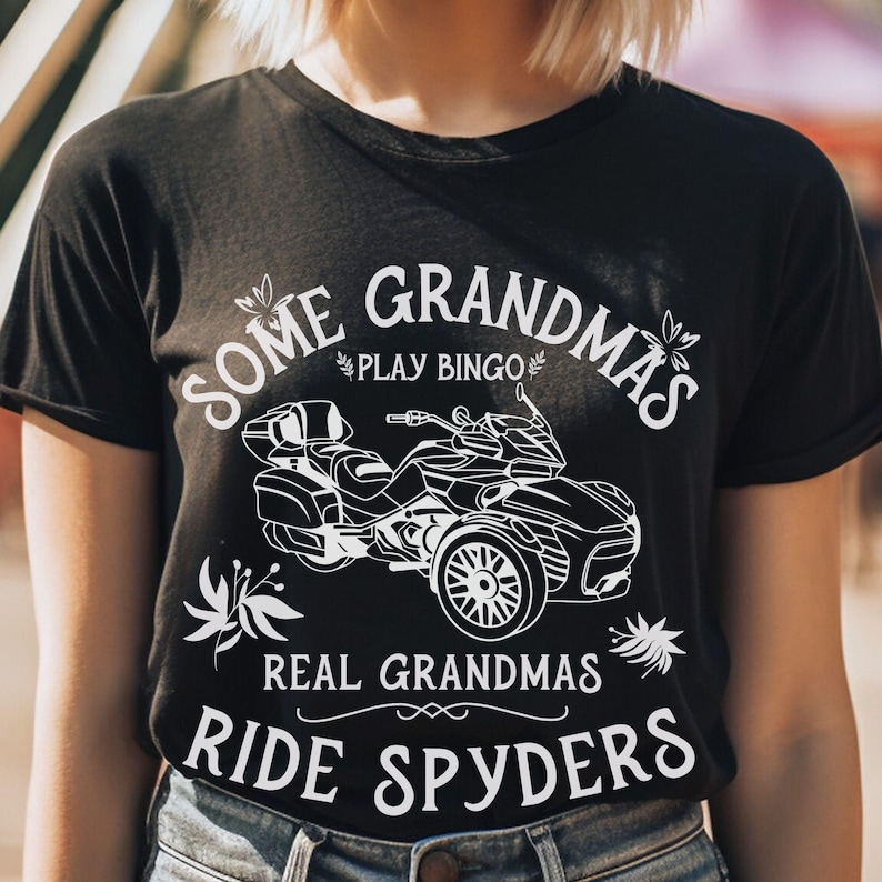 May include: Black t-shirt with white text that reads "Some Grandmas Play Bingo Real Grandmas Ride Spyders" and a white silhouette of a motorcycle.