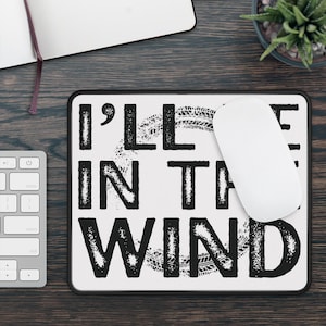 May include: White mouse pad with black text that reads "I'll leave in the wind" with a tire tread pattern design.
