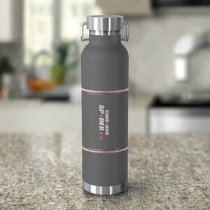 Pu&ograve; includere: Una borraccia termica grigia con coperchio e base argentati. La bottiglia presenta una fascia con la scritta "Can-am SPYDER F3" in bianco e rosso. Ha un manico ed &egrave; alta circa 25 cm.