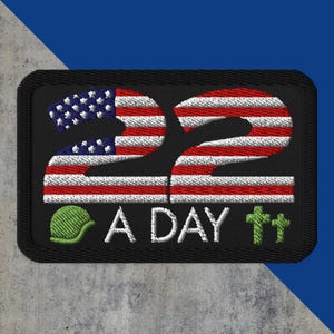 May include: Embroidered patch with the number "22" in red and white stripes, resembling the American flag. The patch includes the text "A DAY" in white, a green helmet, and two green crosses. The patch has a black border.