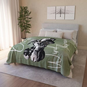 May include: Green fleece throw blanket with a white motorcycle graphic and the text "Open Road and the Wind Therapy".