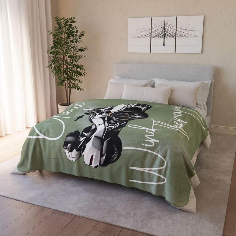 May include: Green fleece throw blanket with a white motorcycle graphic and the text "Open Road and the Wind Therapy".