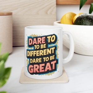 Puede incluir: Taza de cerámica blanca con un diseño gráfico colorido que dice "Atrévete a ser diferente, Atrévete a ser grandioso".
