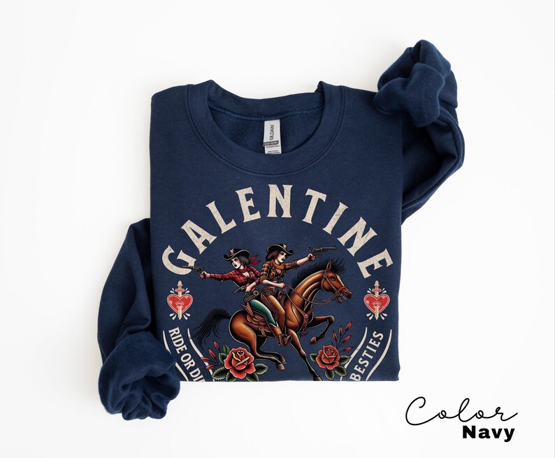 May include: Navy blue sweatshirt with a graphic featuring two cowgirls riding a horse, surrounded by roses and hearts. The text reads "GALENTINE" above and "RIDE OR DIE BESTIES" below. The color is navy.