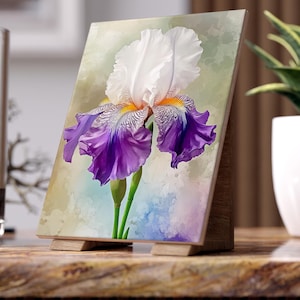 May include: A rectangular art print featuring a detailed illustration of a single iris flower with white upper petals and vibrant purple lower petals, displayed on a small wooden easel stand against a soft, watercolor-style background.