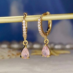 a pair of gold earrings with pink stones