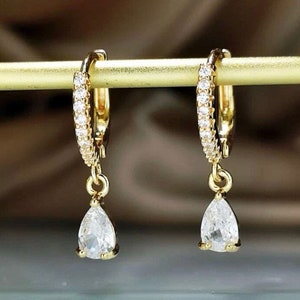 a pair of gold earrings with white stones