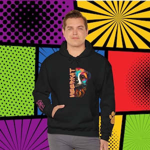 May include: Black hooded sweatshirt with a colorful meerkat graphic on the front. The graphic features a meerkat with a bright orange, pink, blue, and green color scheme. The word "MEERKAT" is written vertically on the left side of the graphic. The sweatshirt has a kangaroo pocket and a drawstring hood.