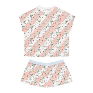 May include: Pink and white pajama set with a martini glass print. The top has short sleeves and the shorts have a light blue waistband.
