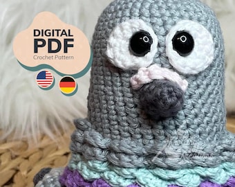 Op de afbeelding: Een grijze gehaakte duif amigurumi met grote zwarte veiligheidsogen op witte patches, een donkergrijze snavel en een nekplooi met lagen lichtblauw, paars en grijs garen. De tekst luidt DIGITAL PDF Crochet Pattern.