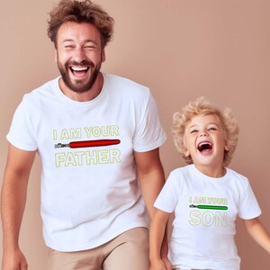 May include: Two white t-shirts with a lightsaber graphic and the text "I am your Father" and "I am your Son".