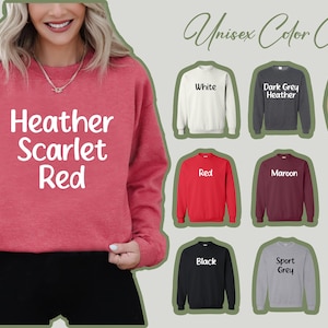 May include: Unisex color chart for sweatshirts. The chart shows 12 different colors, including white, red, maroon, black, and forest green. The text "Heather Scarlet Red" is displayed on a red sweatshirt.