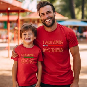 a father and son wearing matching red shirts