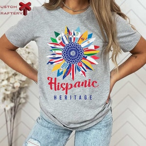 a woman wearing a gray tee shirt with the words hispanic heritage on it