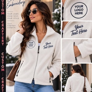 May include: A white fleece zip-up jacket featuring custom embroidery options. The jacket includes a high collar, long sleeves, and two zippered side pockets. Dark blue text on the chest reads YOUR LOGO HERE and Your Text Here.