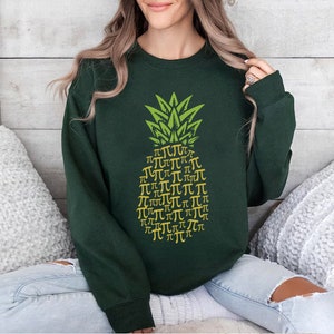 a woman sitting on a bed wearing a green sweatshirt
