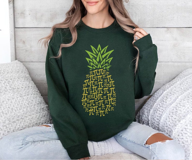 a woman sitting on a bed wearing a green sweatshirt