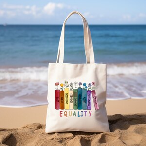 a tote bag sitting on a beach with the ocean in the background