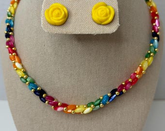 Könnte beinhalten: Eine regenbogenfarbene Perlenkette mit goldenen Akzenten und passenden gelben rosenförmigen Ohrringen.