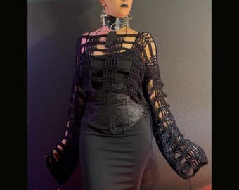 Può includere: Una persona indossa un top nero all'uncinetto strappato, un corsetto e una gonna. Il top ha maniche lunghe con sezioni aperte. L'immagine include il testo "DISTRESSED ASSEMBLY" e "PDF DOWNLOAD ONLY".
