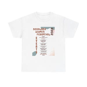 May include: White t-shirt featuring the text "DEADLOCH WINTER FEASTIVAL" in a retro font. The design includes event details and the year 2022. The shirt has a crew neck and short sleeves.