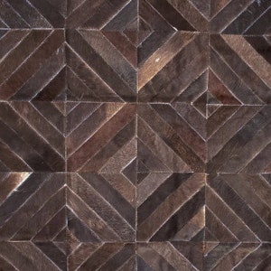 K&ouml;nnte beinhalten: Ein brauner Lederteppich mit einem geometrischen Muster aus Quadraten und Rauten. Der Teppich ist aus verschiedenen Braunt&ouml;nen gefertigt und hat einen rustikalen, Vintage-Look.