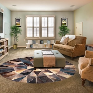 May include: A living room with a large, geometric patterned rug in shades of brown, blue, and beige. The room features a sofa, armchair, and a coffee table. A large TV is mounted on the wall.