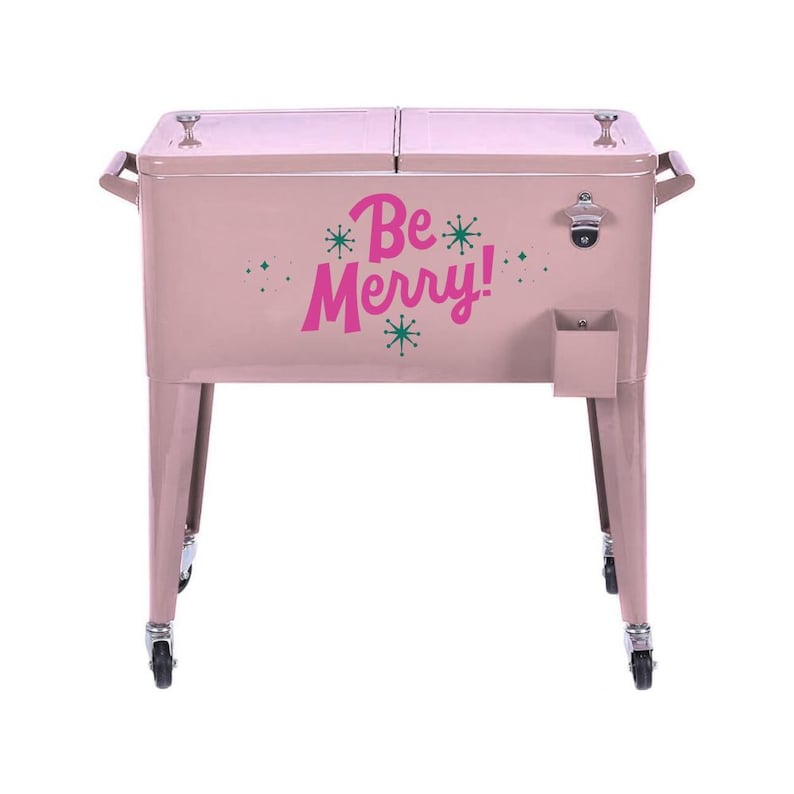 May include: A pink metal cooler with the words "Be Merry!" in magenta. The cooler has a bottle opener, a small storage compartment, and is on wheels. It has handles on each side.