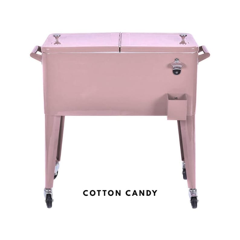 May include: A cotton candy pink metal cooler with a bottle opener and a small storage compartment. The cooler has two hinged lids, handles on the sides, and sits on four legs with wheels. The text "COTTON CANDY" is at the bottom.