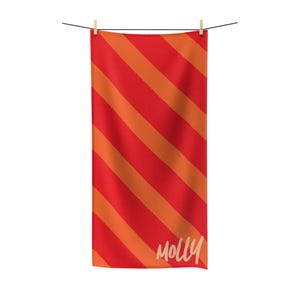 May include: Red and orange striped beach towel with the name "Molly" written in white on the bottom right corner.