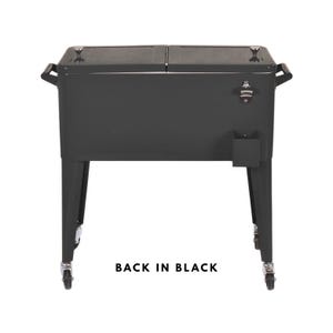 May include: A black metal cooler with a bottle opener and a small storage compartment. The cooler has two hinged lids, handles, and sits on four legs with wheels. The text "BACK IN BLACK" is printed at the bottom.