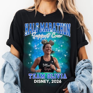 May include: Black t-shirt with the text "HALF MARATHON Support Crew" in blue and white. The shirt features a photo of a woman wearing Minnie Mouse ears and the text "TEAM OLIVIA DISNEY, 2026".