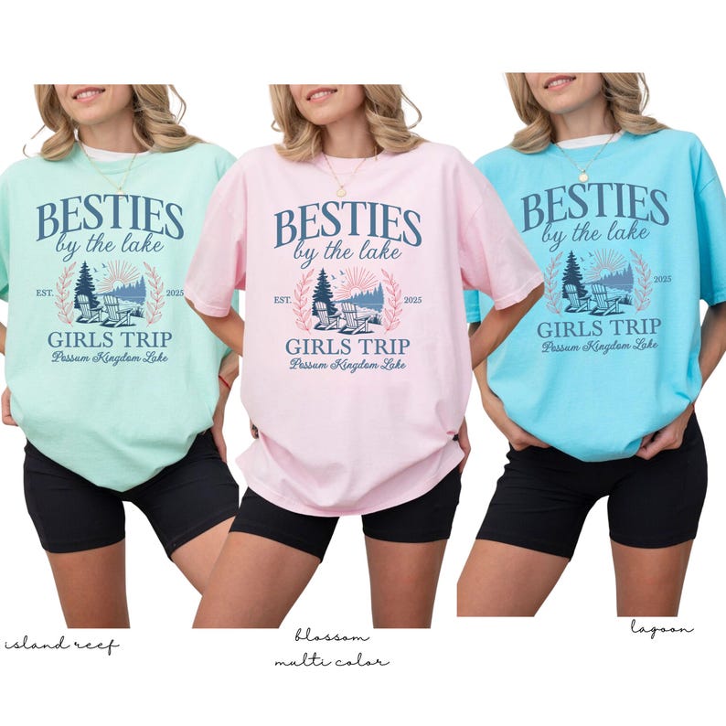 K&ouml;nnte beinhalten: Drei T-Shirts in den Farben Island Reef, Blossom und Lagoon. Jedes Shirt tr&auml;gt den Text "BESTIES by the lake" &uuml;ber "GIRLS TRIP" und "Possom Kingdom Lake". Die Shirts sind kurz&auml;rmelig und werden mit schwarzen Shorts getragen.