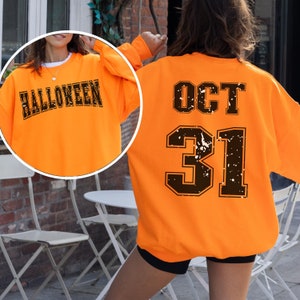 May include: Orange sweatshirt with the word "HALLOWEEN" printed on the front and "OCT 31" printed on the back.