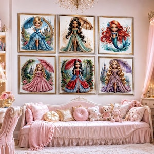 May include: A set of six square wall art prints featuring stylized illustrations of fairy tale characters, including princesses and a mermaid, displayed in a grid arrangement above a pink upholstered daybed with decorative pillows.